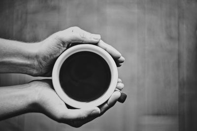 Midsection of person holding coffee cup