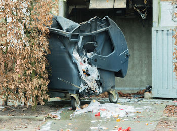 Broken garbage can against wall