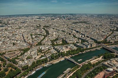 Aerial view of river amidst city buildings against sky