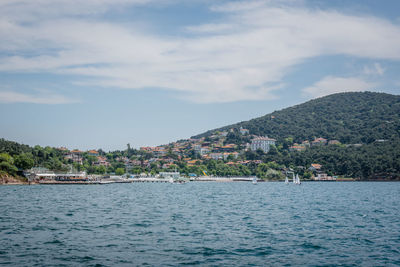 Scenic view of sea by town against sky