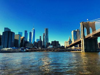 City at waterfront against blue sky