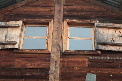 Low angle view of window of old abandoned house