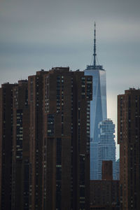 Buildings in city against cloudy sky