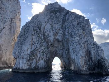 Scenic view of rock formation in sea against sky