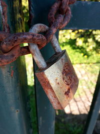 Close-up of rusty padlock on metal fence