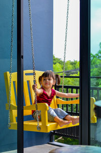 Full length of girl sitting on swing