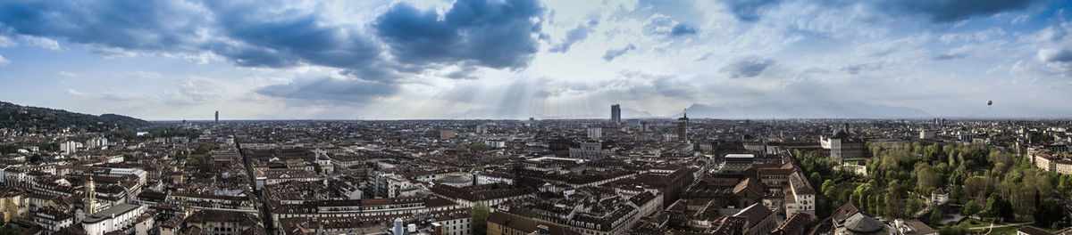 View of cityscape against cloudy sky