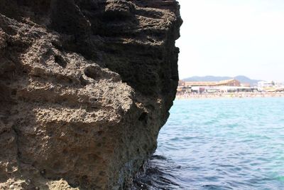 Close-up of rock formation in sea against sky