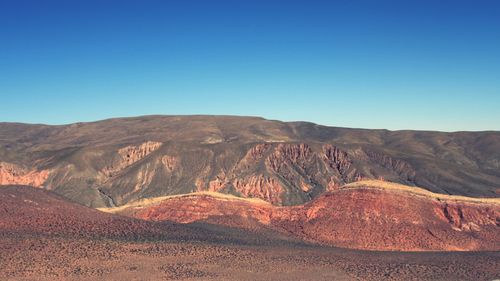 Scenic view of desert against blue sky