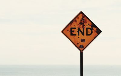 Information sign on sea against sky