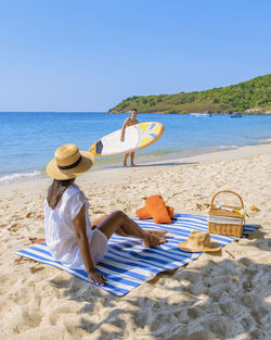 Rear view of woman sitting at beach