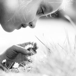 Close-up of woman with dandelion flower on field