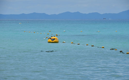 Yellow kayak and buoys on sea