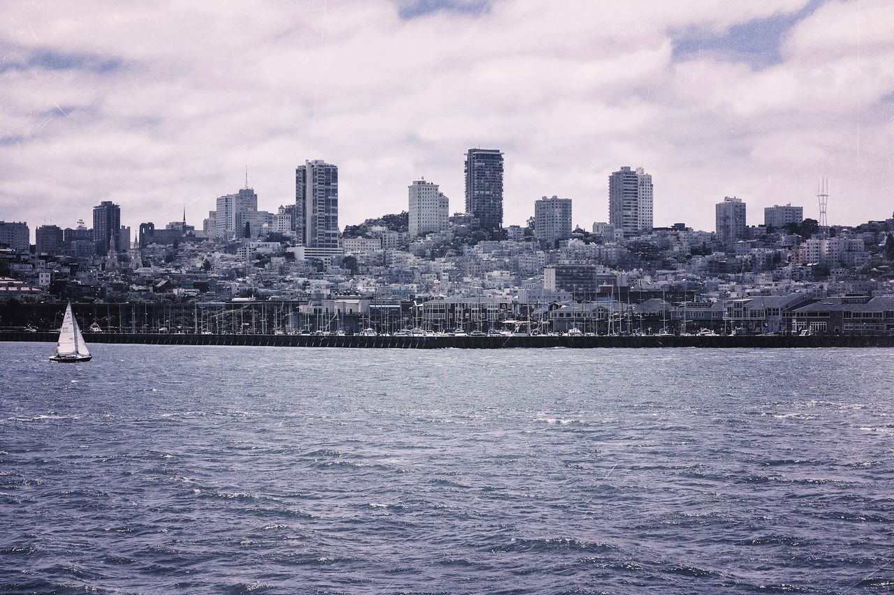 SCENIC VIEW OF SEA BY CITYSCAPE AGAINST SKY