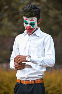 Portrait of young man wearing sunglasses standing on field