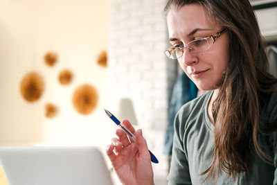 Work from home. middle aged brunette woman with glasses works at home online.