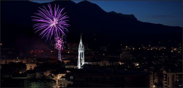 Firework display in city at night