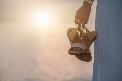 Close-up of hand holding umbrella against sky