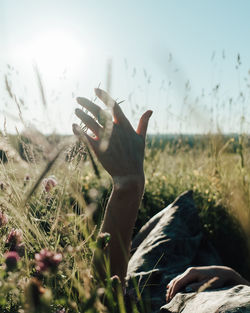 Midsection of woman by plants against sky