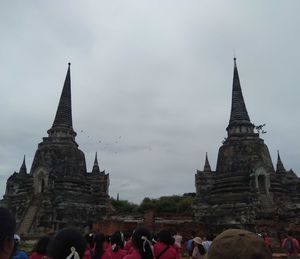 Group of people in front of historic building against sky