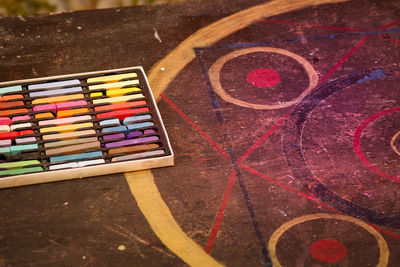 High angle view of multi colored crayons by drawing on table
