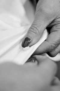 Close-up of woman holding hands on bed