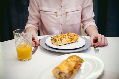 Midsection of woman by food on table