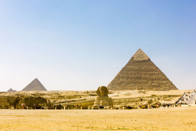 The sphinx statue at giza pyramids against sky