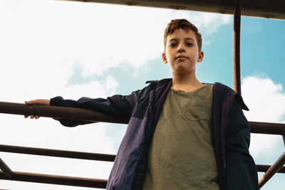 Portrait of boy standing against sky