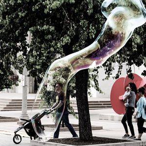 People holding sculpture against trees