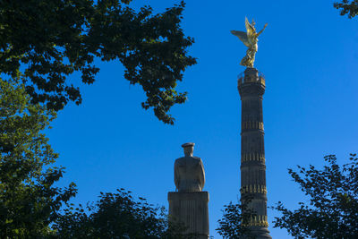 Low angle view of statue against blue sky