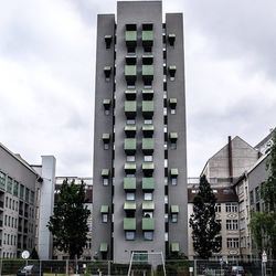 Low angle view of buildings against cloudy sky