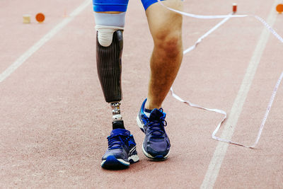 Low section of man walking on road