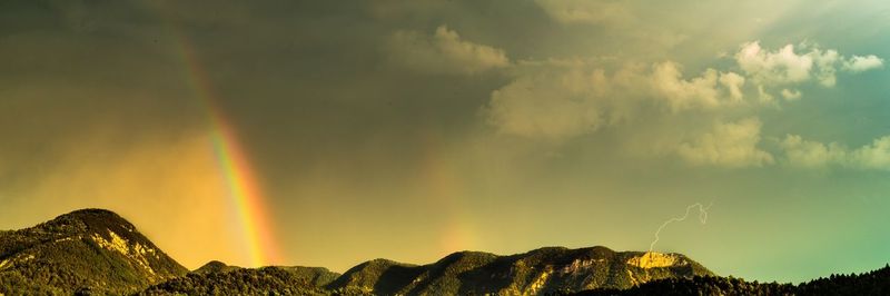 Low angle view of rainbow over mountains against sky