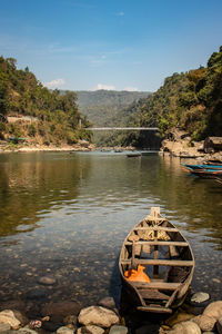 Boat moored on lake against sky