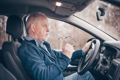 Midsection of man sitting in car