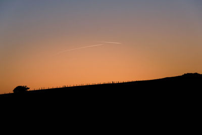 Silhouette landscape against clear sky during sunset