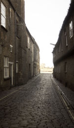 Empty alley amidst buildings in city