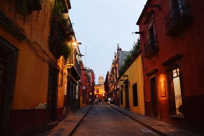 Alley amidst street in city