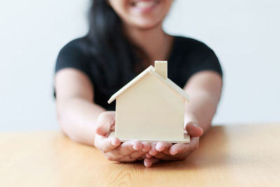 Midsection of woman holding model home