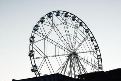 Low angle view of ferris wheel against clear sky