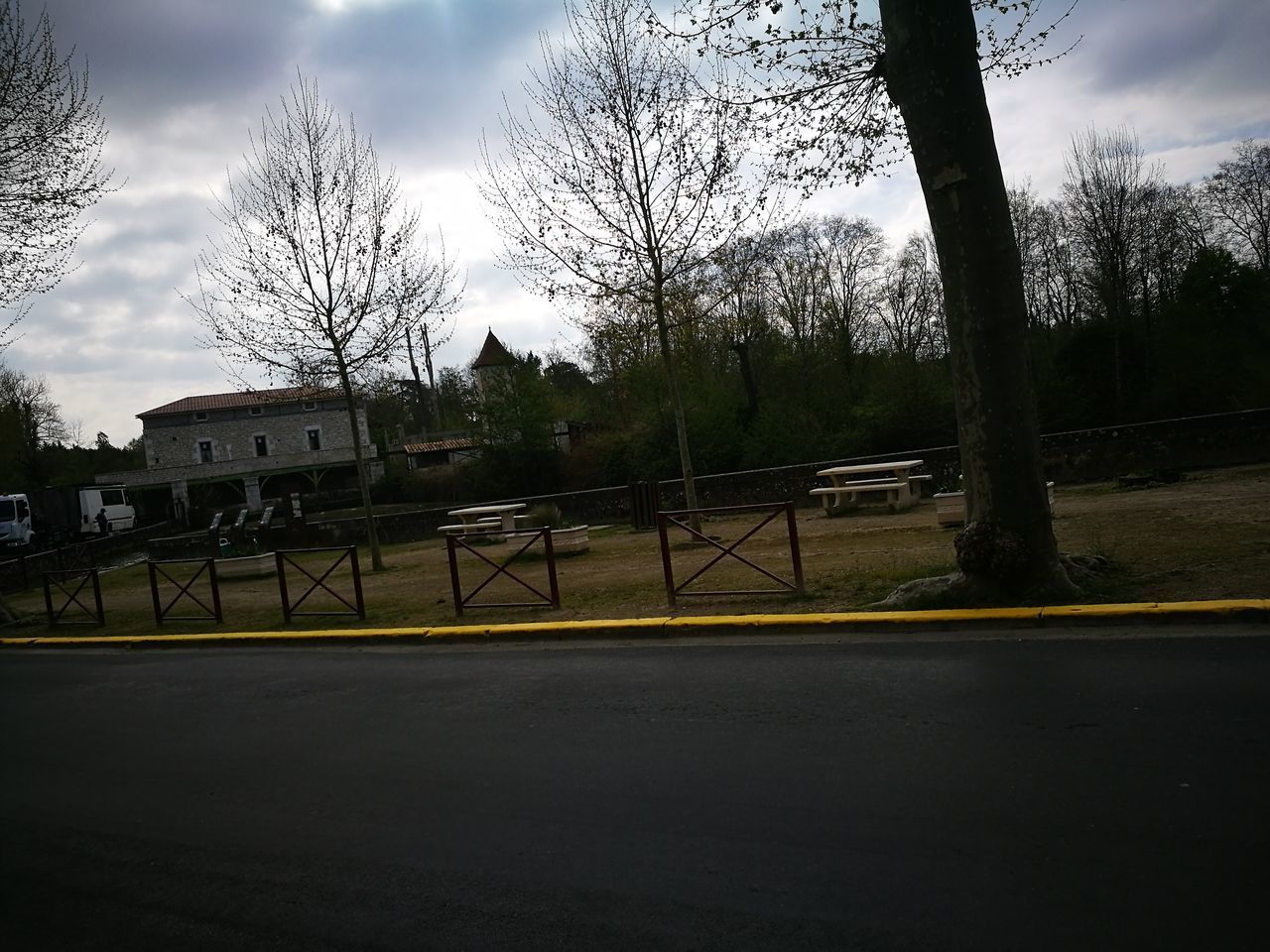 ROAD BY TREES IN CITY AGAINST SKY