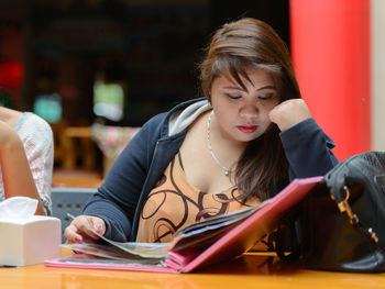 Portrait of young woman sitting on table