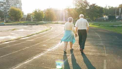 Rear view of people walking on road