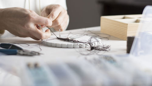 Close-up of woman working with thread on table