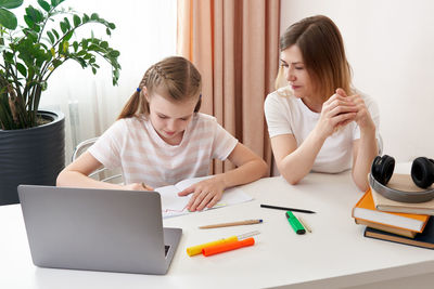 Mother helping daughter with homework