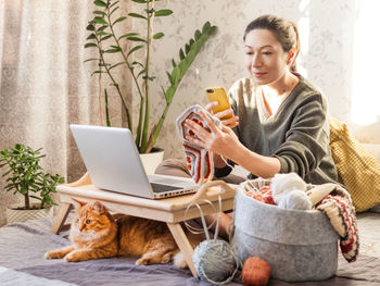 Woman takes photo of crocheted part of clothes. learn to knit from lessons on internet.  hobby. 