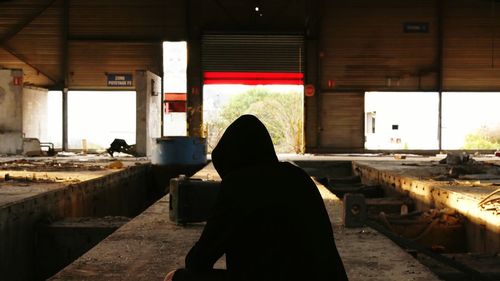 Rear view of woman sitting on bench
