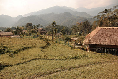 Houses by trees and mountains against sky