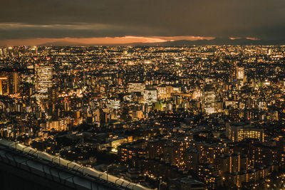 High angle view of illuminated cityscape against sky at night